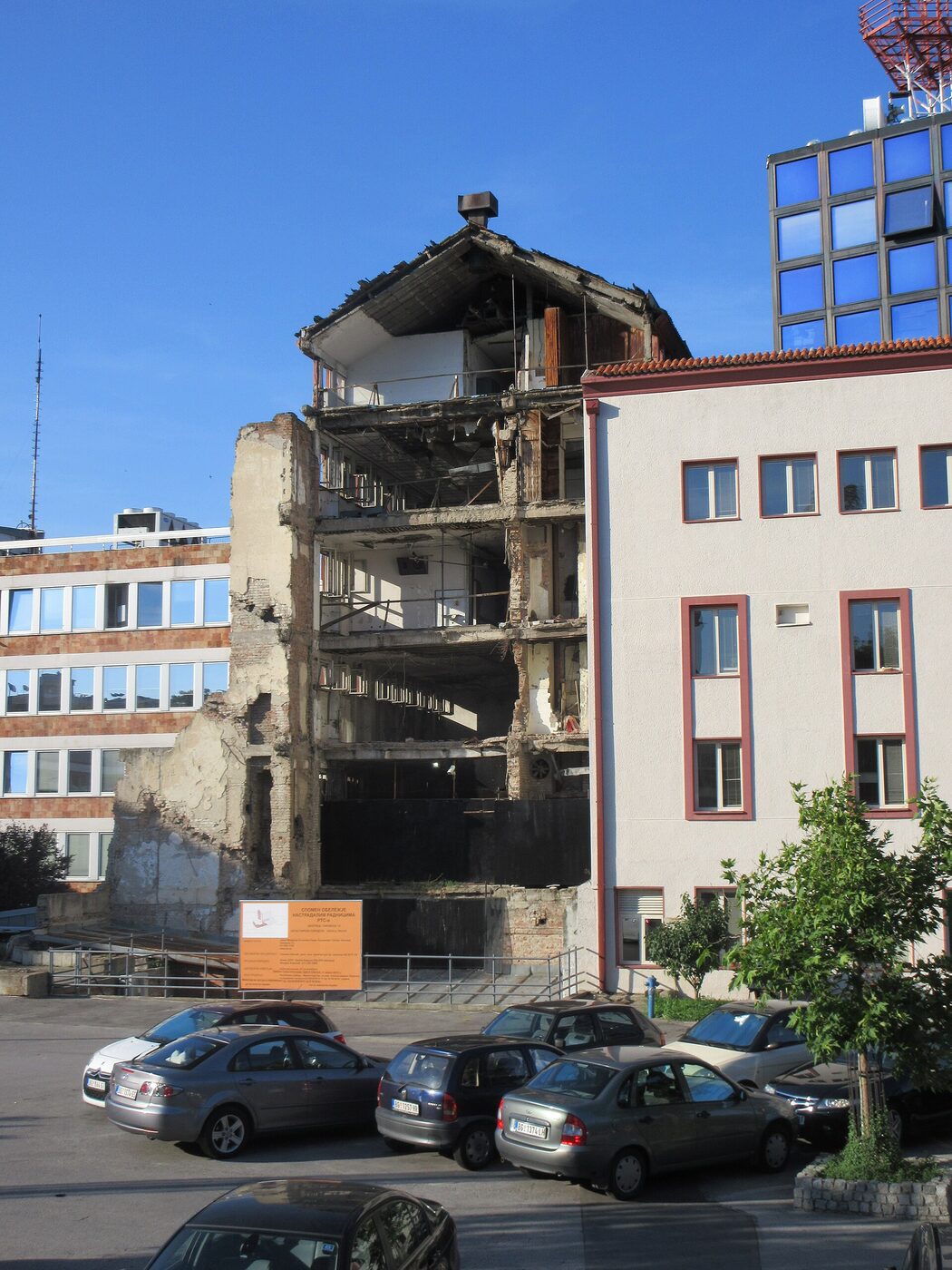 A ruined multi-storey building in Belgrade with its facade torn open, damage left from the 1999 bombing.