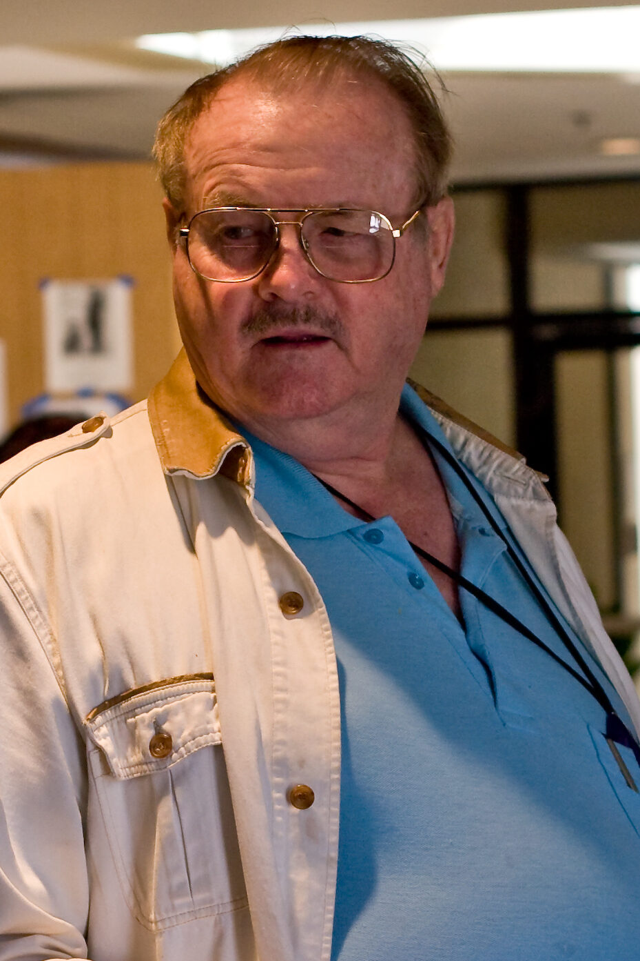 Jerry Pournelle, an older bearded man in a dark shirt, seated and speaking at a science-fiction convention in 2006.