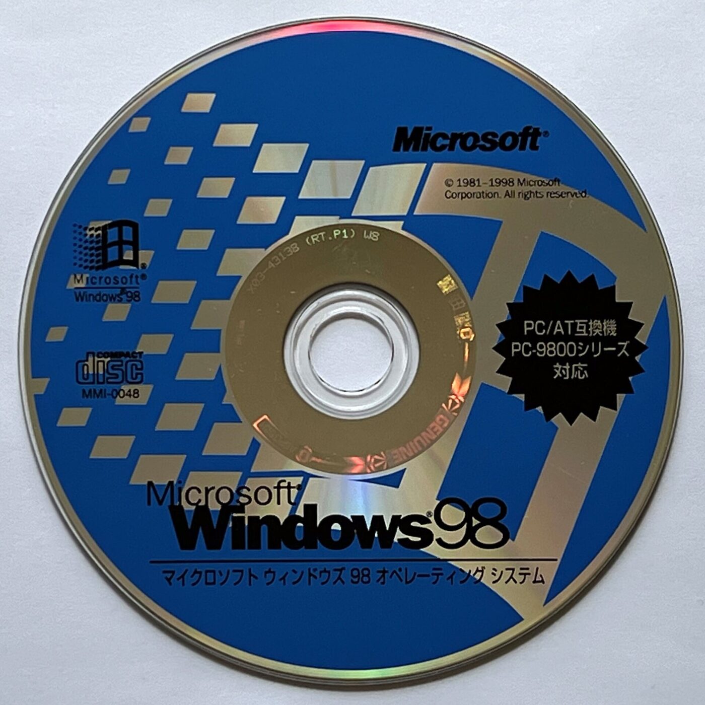 A CD-ROM with a blue and gold label reading Microsoft Windows 98, with Japanese text beneath the logo.