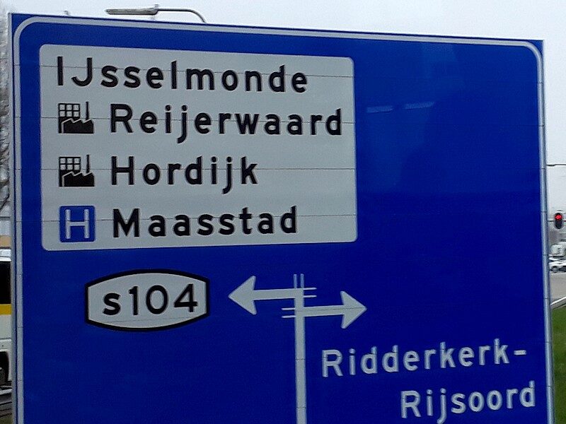 A blue Dutch road sign with a white panel listing IJsselmonde, Reijerwaard, Hordijk and Maasstad; the first name begins with a capital I and capital J together.
