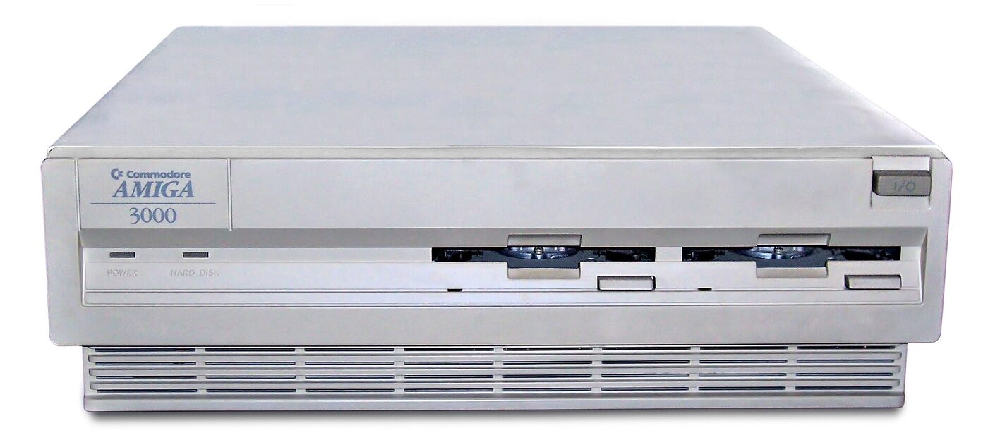 Front view of a beige Commodore Amiga 3000 desktop computer case with two floppy drive slots, power and hard disk indicator lights and a ventilation grille along the base.