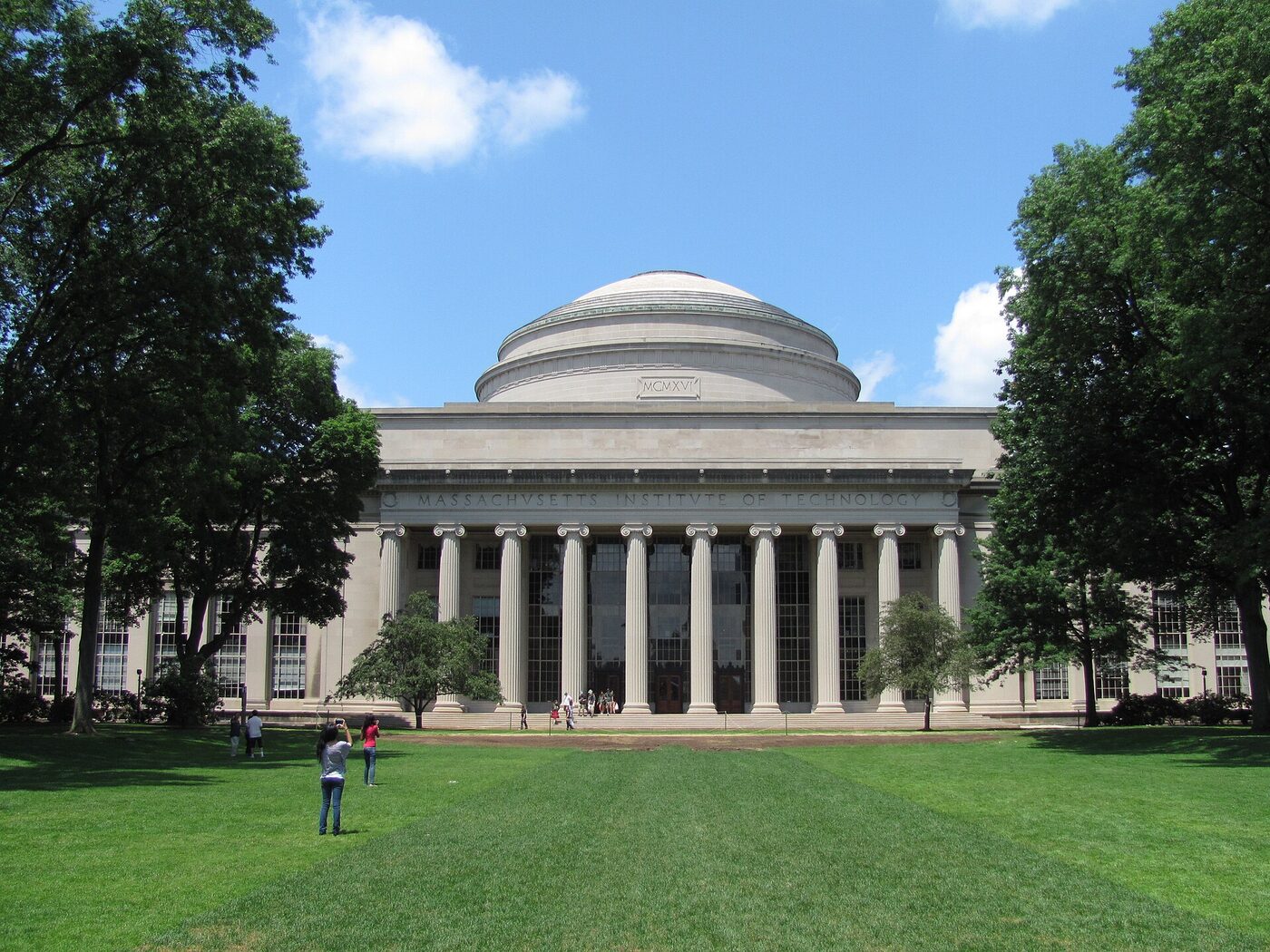A neoclassical limestone building with a large dome above a columned portico, seen across an open lawn.