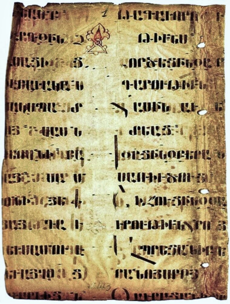 A worn rectangular parchment leaf in two columns, carrying lines of angular handwritten Armenian capitals.