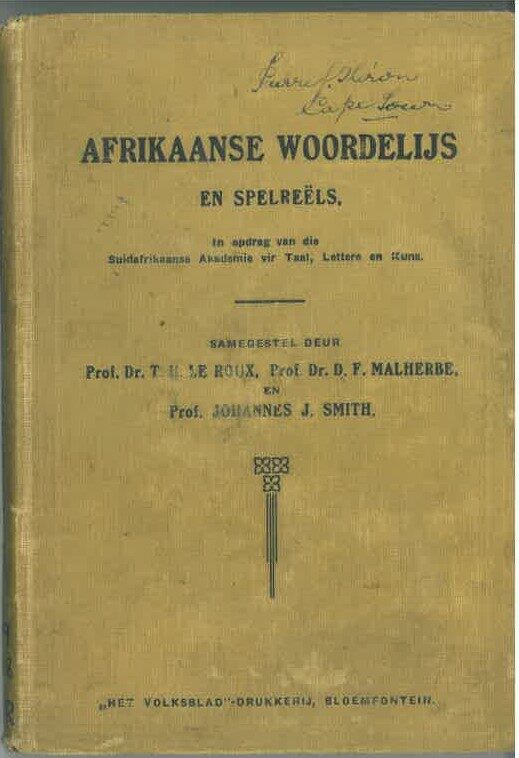 The plain cloth front cover of a small 1917 book, lettered Afrikaanse Woordelijs en Spelreëls with the three compilers' names and the printer's imprint, an owner's signature inked at the top.
