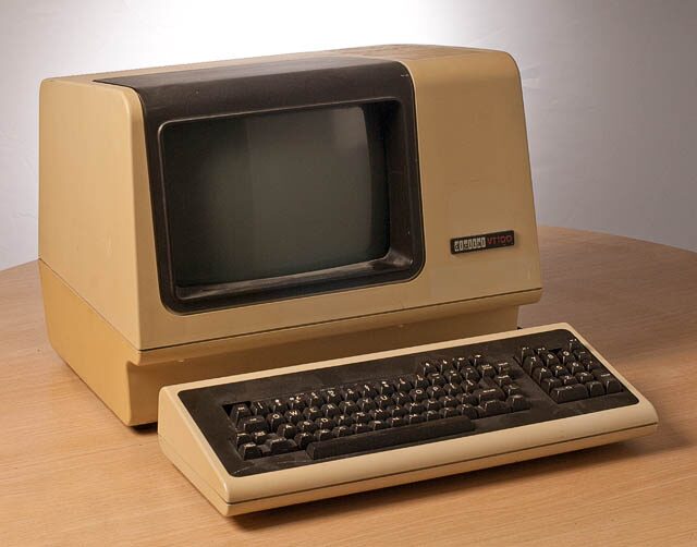 A DEC VT100 computer terminal: a beige monitor case with a small monochrome screen and detached keyboard.